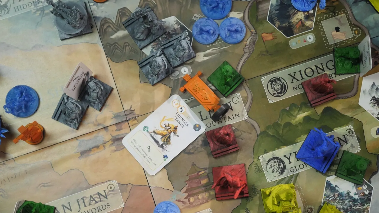 Squads of grey, blue, red and green miniatures spread across the regions of the map, seen from above