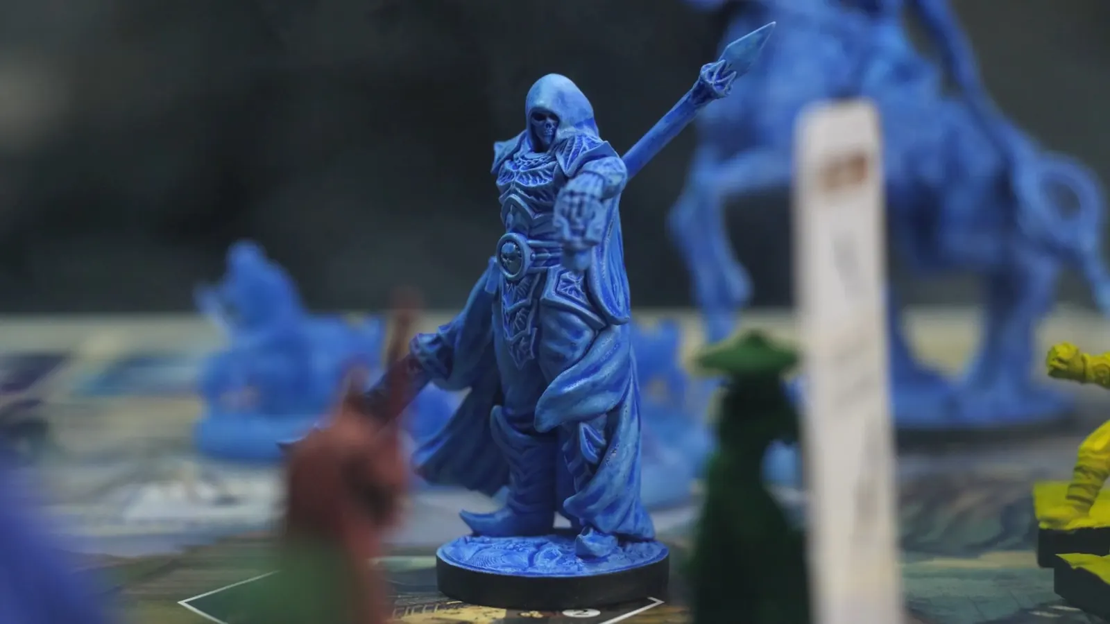 Close-up of a hooded blue spearman, with a mounted figure behind