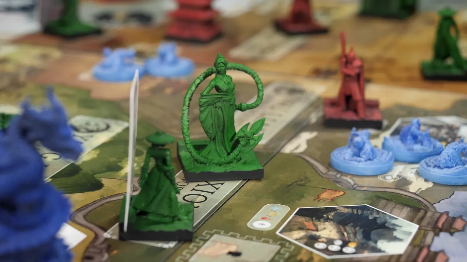 A green figure standing inside a ring, with red and green warriors and blue units around